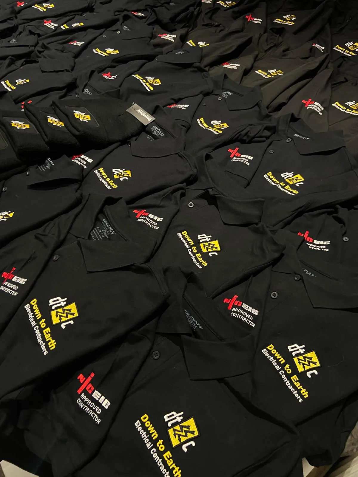 A pile of black shirts sitting on top of a table.